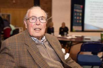 older gentleman in suit jacket sitting in office