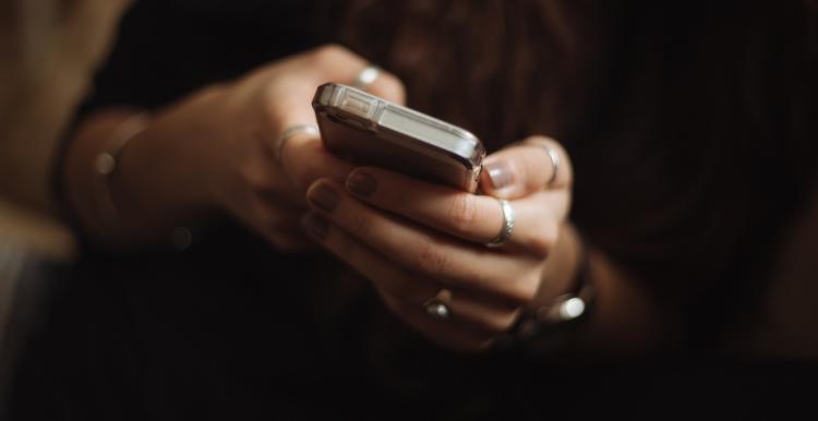 A image of hands holding a mobile phone to suggest online gambling