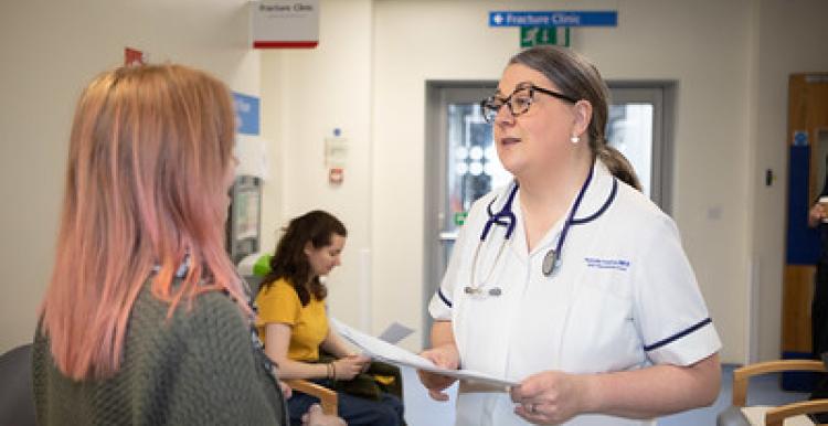 A woman patient talking to a nurse in a waiting room 