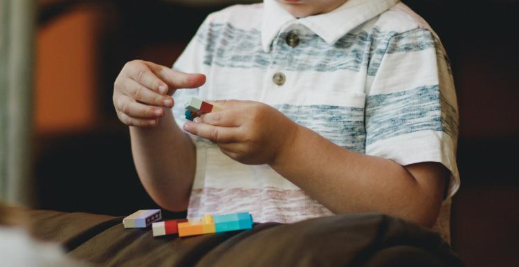 A young boy sits and plays with toys