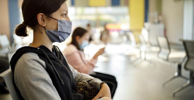 A young woman sits in a waiting room