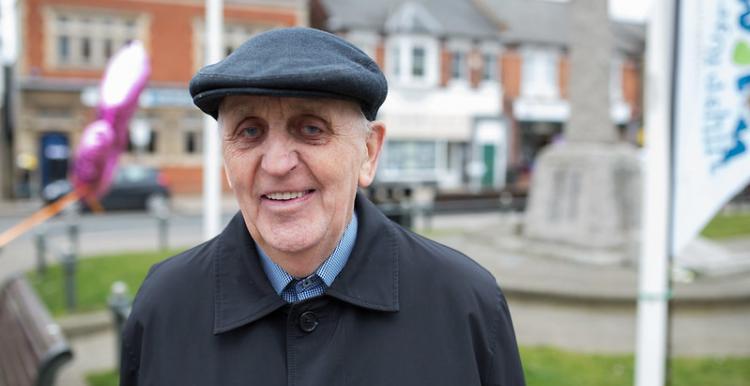 older man standing in street