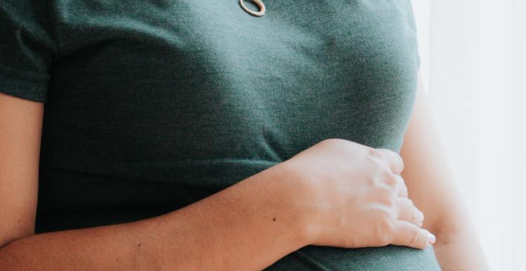 A pregnant woman in a grey T shirt 