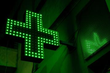 A bright green luminous pharmacy cross