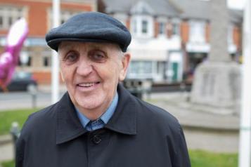 older man standing in street